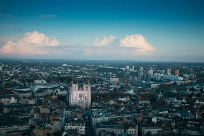 Vue aérienne des toits de Nantes jusqu’à la cathédrale, sous un ciel de fin de journée