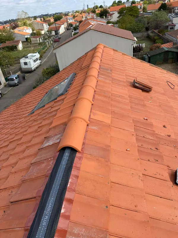 Toit en tuiles mécaniques orangées pendant la repose du faîtage, chantier Cam Couverture
