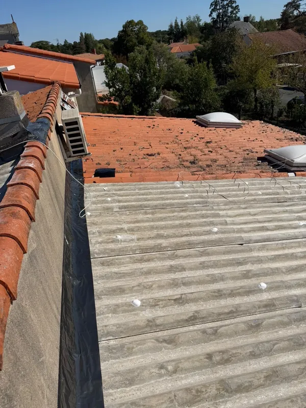 Bande d’étanchéité neuve le long du raccord entre une couverture en plaques et un mur