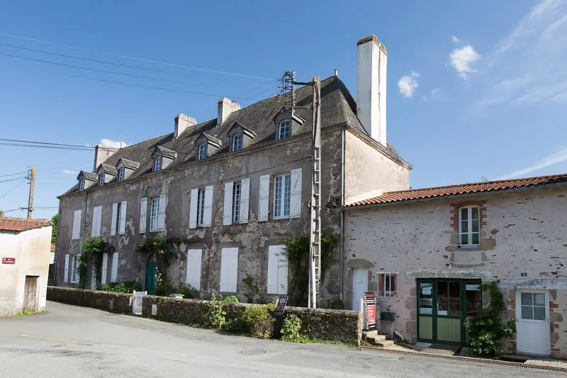 Maison de bourg à Montaigu-Vendée, toit d’ardoise à lucarnes, à côté d’une maison couverte de tuiles