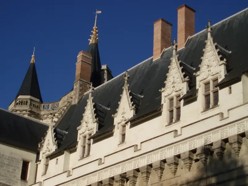 Toit d’ardoise à hautes lucarnes de pierre et souches de cheminée en brique du château des ducs, à Nantes